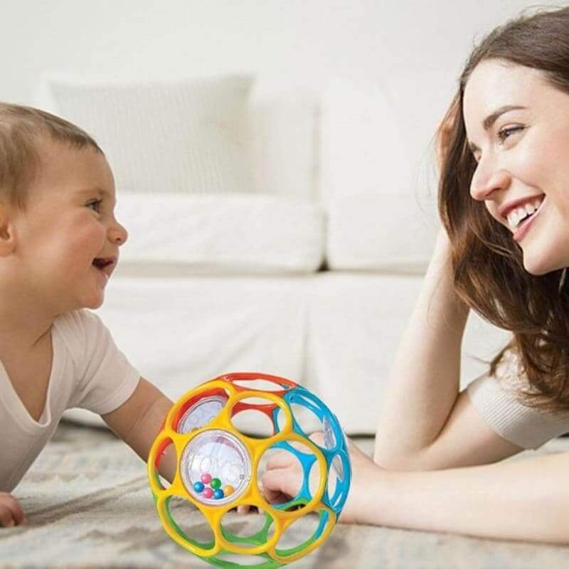 bébé-explorant-les-couleurs-et-les-formes-avec-son-hochet-balle